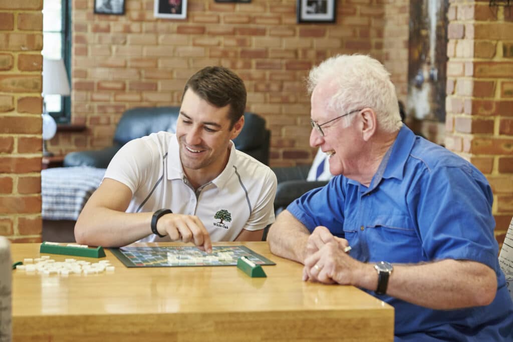 a White Oak carer playing board games with an elderly man